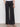 A person stands against a white wall wearing Sanctuary Clothing's cruiser full length black trousers with front patch pockets and black heeled sandals, hands in pockets, lower body only visible.