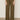 A person wearing the Sanctuary Clothing cruiser full length mossy green pants is shown from the waist down, standing against a plain beige background. The pants have front patch pockets and a wide-leg design.