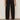 A person wearing Sanctuary Clothing's polished barrel pant in black with black heeled sandals, standing against a light wall and concrete floor. Only the lower half of the body is visible.
