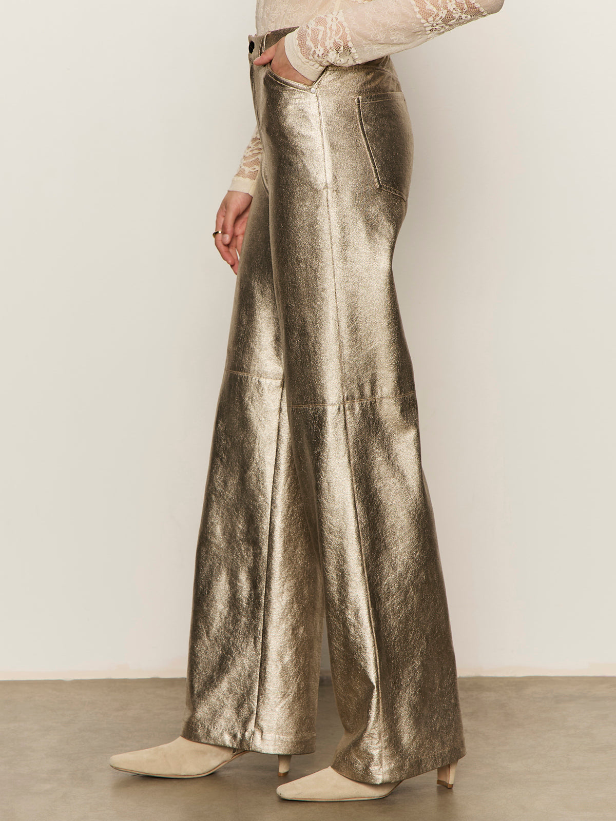 Person wears Sanctuary Clothing's Cadence Relaxed Straight Pant in platinum, paired with cream ankle boots and a lace top. The cropped image shows only the lower body against a plain background.