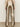 A person faces away on a neutral background, wearing Sanctuary Clothing's cadence relaxed straight pant in platinum€�a high-waisted metallic gold style with back pockets, slight flare, and a lace long-sleeve top.