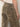 A person wearing Sanctuary Clothing's cadence relaxed straight jean in light bronze, featuring a high waist, visible back pockets, and a small "Sanctuary" label on the right pocket, stands with their right hand at their side.