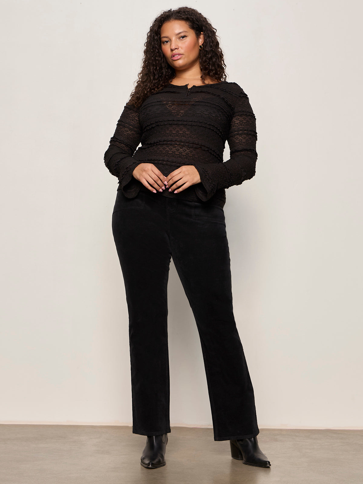 Woman wearing a black outfit against a plain background