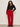 Woman wearing a black top and red pants against a plain background