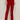 A person wears Sanctuary Clothing's velveteen brook bootcut pant in cherry lacquer (petite), styled with a black long-sleeve top and black heeled ankle boots, standing against a neutral background.