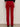 A person stands facing a beige wall, shown from the waist down, wearing Sanctuary Clothing's velveteen brook bootcut pant in cherry lacquer (petite sizing) with two back pockets and a black label, paired with black heeled shoes.