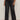 A person wearing Sanctuary Clothing's tuxedo relaxed straight jean black tie extended sizing, styled with black ankle boots. The photo highlights the lower half of their body against a plain background.