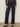 Wearing Sanctuary Clothing's marine full length jean first sight, styled with a black floral long-sleeve top and black low-heeled shoes. The individual stands against a plain light background; image cropped below the shoulders.