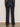 A person wearing Sanctuary Clothing„¢s marine full length jean first sight, shown from the back, stands on a light brown floor against a neutral wall.