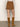 A person wearing a cream knit sweater, knee-high tan suede boots, and the Sanctuary Clothing briar corduroy mini skirt in bronze stands facing away from the camera against a plain background.