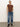 A woman poses against a plain background wearing Sanctuary Clothing's "the perfect tee boheme," styled with blue cuffed jeans and black heeled boots, one hand in her pocket and a neutral expression.