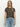 A person with long blonde hair wears Sanctuary Clothing's "the perfect tee french kitty" and light blue jeans, standing against a plain white background and looking directly at the camera with a neutral expression.