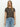 A person with long blonde hair wears Sanctuary Clothing's "the perfect tee french kitty" and light blue jeans, standing against a plain white background and looking directly at the camera with a neutral expression.