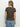 A woman with long, light brown hair faces away, wearing Sanctuary Clothing's "the perfect tee french kitty" and light blue jeans against a plain white background.