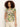 A woman with curly hair models Sanctuary Clothing's "the perfect tee palm," a short-sleeve shirt with a green and pink tropical leaf pattern, paired with light-colored pants against a plain white background.