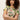 A woman with curly hair stands confidently with arms crossed, modeling the Sanctuary Clothing “the perfect tee palm,” a short-sleeve shirt featuring a green and pink tropical leaf pattern, against a plain background.
