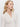 A woman with long blonde hair wears the Sanctuary Clothing dreamgirl lace button up chalk blouse and gold hoop earrings, looking to the side against a plain white background.
