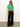 A person models Sanctuary Clothing's all day eyelet tee in palm, tied at the front. They pair it with black wide-leg pants and sandals. The scene is set against a plain background as their long, dark hair cascades down over a necklace they™re wearing.
