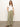 A woman stands against a plain background in an embroidered perfect tee by Sanctuary Clothing and olive green wide-leg cargo pants with pockets. Her long hair flows down as she smiles slightly, hands in pockets, and pairs the look with brown sandals.