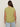 A woman with long brown hair stands facing away, wearing the Sanctuary Clothing knotted muscle tee bamboo extended sizing in light green and light blue jeans against a plain beige background.