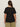 A person with long brown hair wears the Sanctuary Clothing notch neck tee black extended sizing, paired with olive green pants, and stands facing away from the camera against a plain light background.