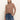A woman with straight, light brown hair models the Sanctuary Clothing long sleeve draped mock neck top in mocha and blue jeans. She stands against a white background with one hand in her pocket, looking at the camera.
