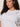 A woman with curly brown hair wears the Sanctuary Clothing embellished tee in white (extended sizing) featuring sparkling jeweled details, paired with gold hoop earrings, standing against a neutral background with a calm expression.