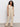 A woman with long curly hair models the Sanctuary Clothing relaxed modern vest in sand sequin stripe, paired with matching wide-leg pants, standing against a plain light background.