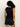A person with curly hair stands with their back to the camera, wearing Sanctuary Clothing's relaxed modern vest in black and black shorts. The top features a bow detail at the back against a plain white background.