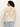 Someone with curly hair is wearing the flower pop open stitch jacket from Sanctuary Clothing's eco natural inclusive collection with light blue jeans, facing away from the camera against a simple, light-colored background.