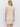 A woman with light hair stands with her back to the camera, wearing the Sanctuary Clothing summer shell dress eco natural, a sleeveless, knee-length crochet dress, against a plain light background.