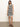 A woman wearing a Sanctuary Clothing summer shell dress in chalk black stripe stands against a plain background, paired with brown sandals.