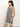 A woman with shoulder-length dark hair looks to the side while wearing Sanctuary Clothing's "summer shell dress" in chalk black stripe, standing against a plain light background.