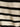 Close-up of the textured sweater vest macrame black stripe 3 by Sanctuary Clothing, highlighting its ribbed fabric with horizontal black and off-white stripes and detailed stitching.
