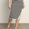 A woman wears the Sanctuary Clothing side slit midi black macrame stripe 2 skirt with a matching top and black sandals, standing on a gray floor against a plain light background.
