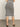 A person models the Sanctuary Clothing side slit midi black macrame stripe 2 skirt with black open-toe heels, standing on a light floor against a plain background.