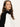 A woman with long brown hair models the Sanctuary Clothing downtown mock neck sweater in black chalk, gazing confidently at the camera against a plain light background.