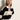 A woman with straight blonde hair models the Sanctuary Clothing polo striped sweater dress in heather pearl with black, featuring a white collar. She stands against a light background, looking slightly aside with a neutral expression.