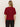 A person with long, straight blonde hair is seen from the back wearing the Sanctuary Clothing short sleeve shine sweater tee in cherry lacquer shine, paired with black pants, against a plain light background.