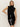 A woman with long blonde hair models the Sanctuary Clothing scarf sweater shell in black, posing with one hand on her hip against a plain light background.