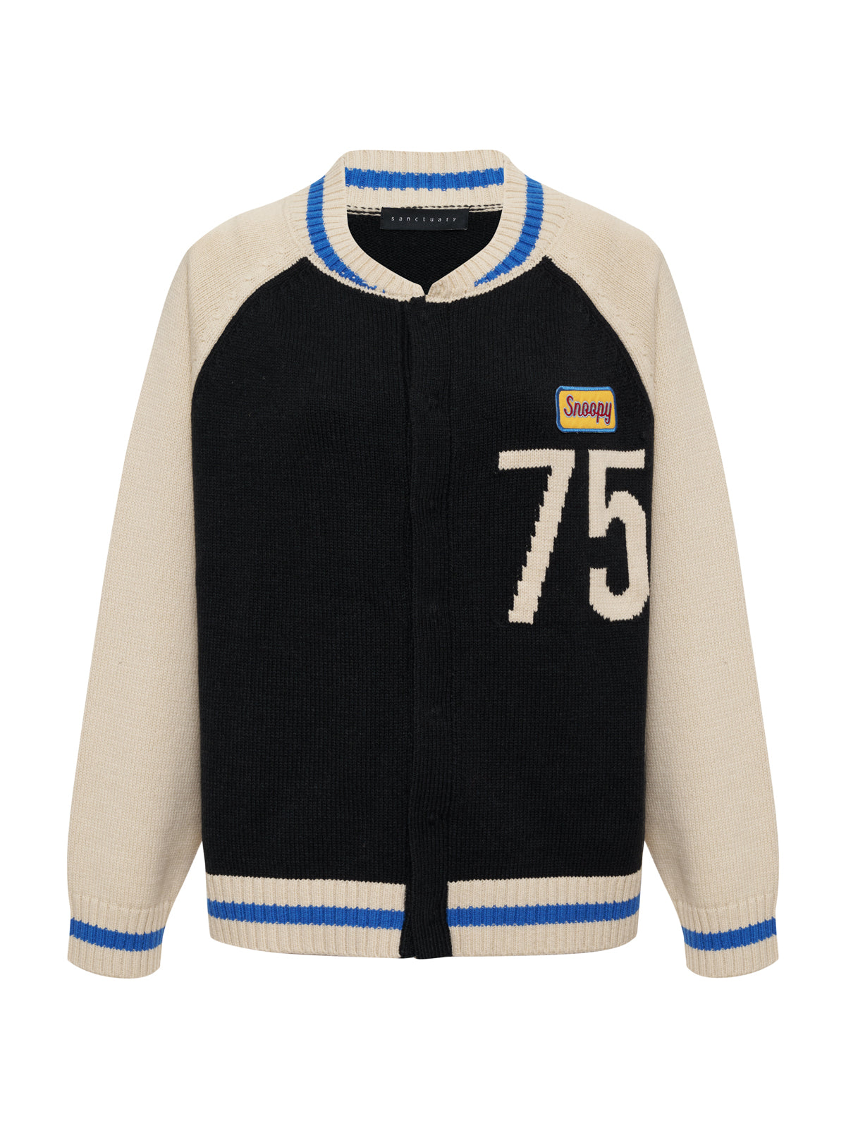 The 75 bomber sweater black chalk by Sanctuary Clothing x PEANUTS 75th Anniversary is a black and cream knit cardigan with blue and white striped cuffs and collar, a large "75," and a yellow "Snappy" patch on the left chest.