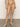 A person stands barefoot on a light brown floor, showcasing the Sanctuary Clothing bright breeze side tie hipster bikini bottom kona against a plain off-white background, with their upper body mostly out of frame.