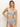 A person wearing the Sanctuary Clothing "refresh rib bandeau blue chateau," featuring a light blue, ribbed strapless bandeau bikini with high-waisted bottoms, stands against a plain background. With shoulder-length hair, they pose confidently with one hand on their hip.