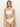 A person with long, straight hair is wearing Sanctuary Clothing's refresh rib bandeau white and high-waisted bikini bottoms, standing forward against a plain, light-colored background.