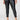 A person is wearing the Runway Legging Black Inclusive Collection from Sanctuary Clothing paired with black open-toe sandals featuring a cork heel. The individual is also wearing a green camouflage top. The background is plain and light-colored.