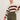 A woman models the Sanctuary Clothing 24/7 Popover Chicory Light Oat (extended sizing) sweater, featuring cream and dark red stripes, paired with olive green high-waisted cargo pants against a plain light background.