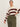 A woman models the Sanctuary Clothing 24/7 Popover Chicory Light Oat (extended sizing) sweater, featuring cream and dark red stripes, paired with olive green high-waisted cargo pants against a plain light background.