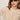 A woman with straight light brown hair wears oval dark sunglasses, gold hoop earrings, and the Sanctuary Clothing boheme popover light oat sweater, standing against a light background.