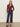 A woman stands against a plain light background wearing the Sanctuary Clothing dreamgirl lace button up night berry. Her hands are in her pockets and her long hair is loose.
