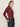 A woman with long light brown hair wears the Sanctuary Clothing dreamgirl lace button up night berry top and dark high-waisted jeans, hands in her pockets, standing against a plain light background.